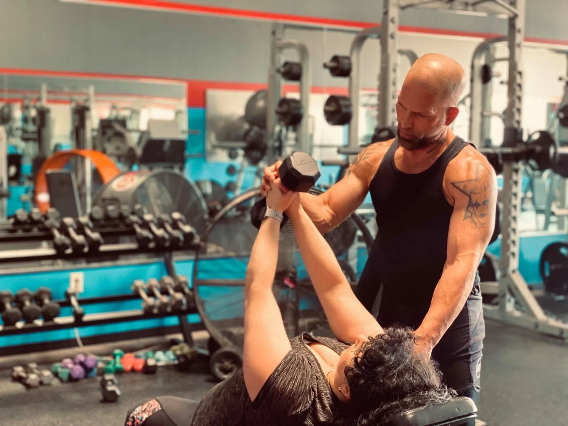 Woman lifting weights under trainer guidance